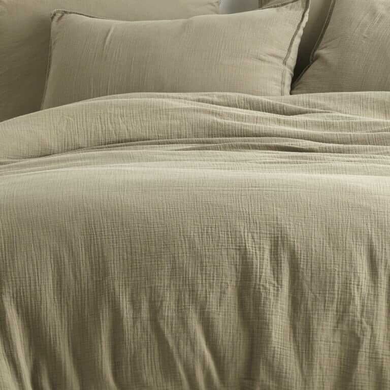 Comfortable bed with wooden frame with many pillows, blankets and sheets in the interior of a stylish bedroom