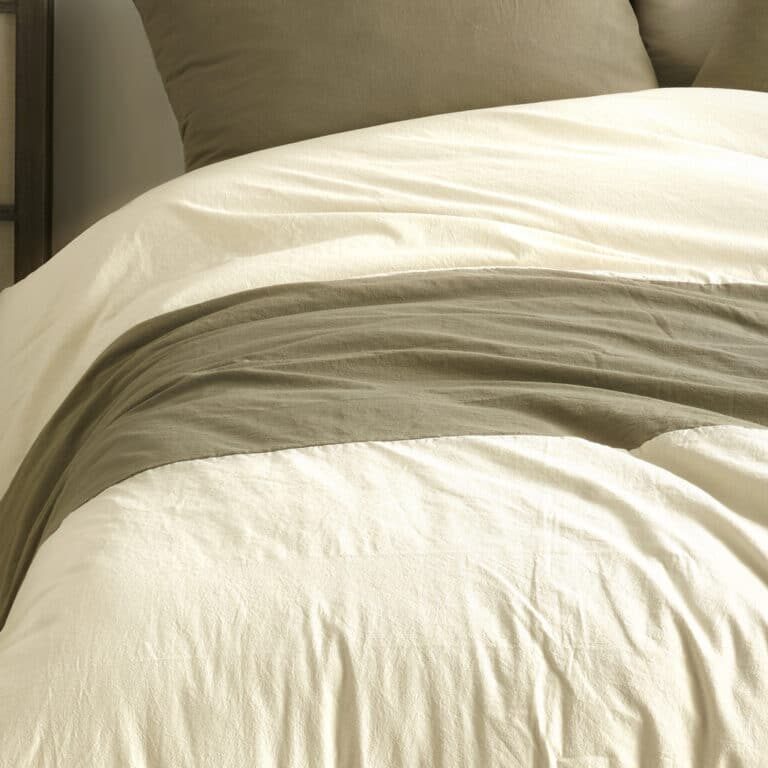 Comfortable bed with wooden frame with many pillows, blankets and sheets in the interior of a stylish bedroom