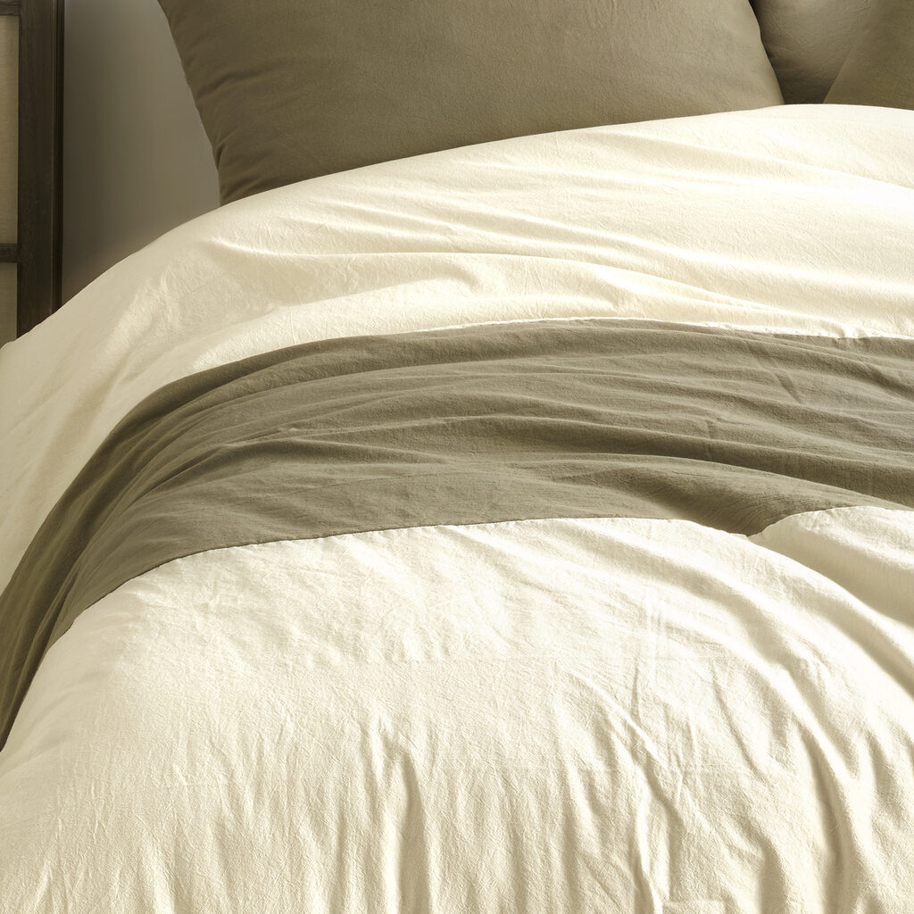 Comfortable bed with wooden frame with many pillows, blankets and sheets in the interior of a stylish bedroom