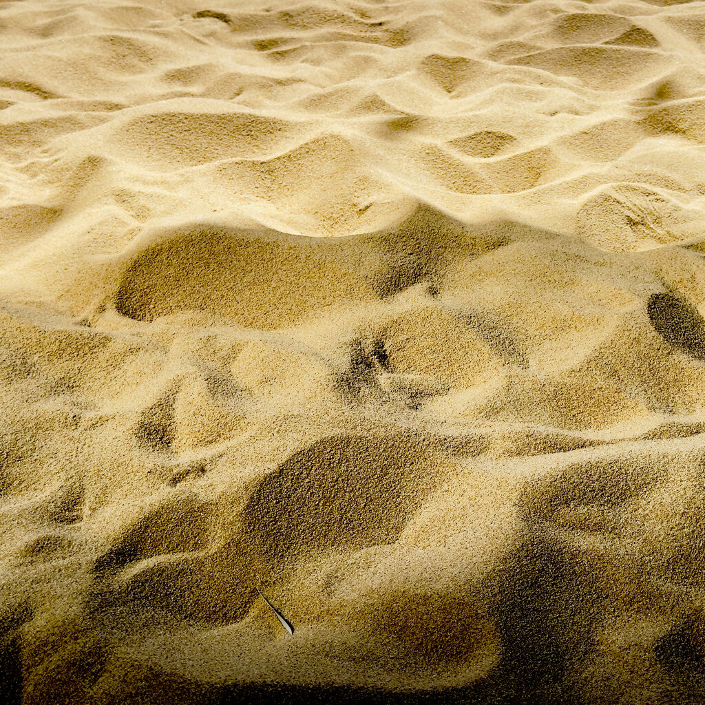 Golden Sand Texture Nature Close-up of attractive golden sand, showing the naturally curved surface and fine sand grains. This image focuses on the interaction of light and shadow. Nature,
